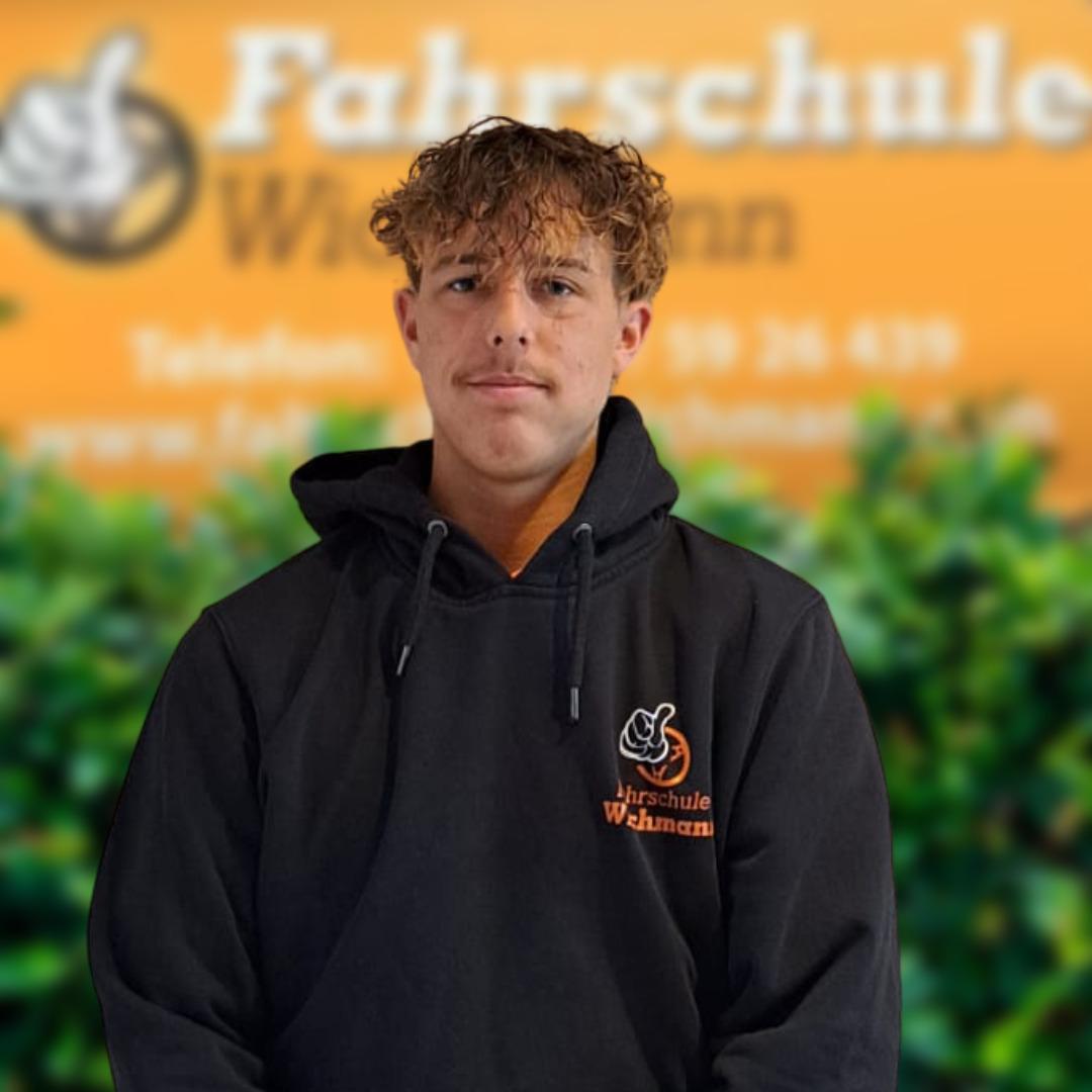 Junger Mann im Wichmann-Hoodie vor Fahrschule Wichmann Rastede Hintergrund