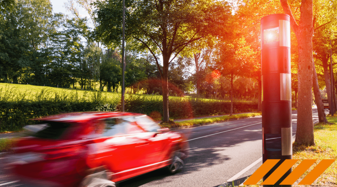 Roter Pkw auf sonniger Allee in Rastede wird von modernem Blitzer fotografiert