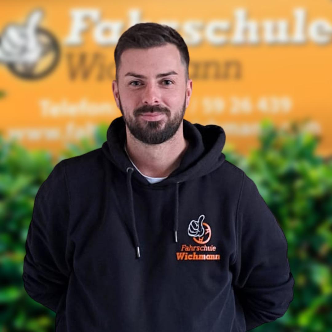 Fahrlehrer im schwarzen Hoodie mit Fahrschule Wichmann Logo in Rastede