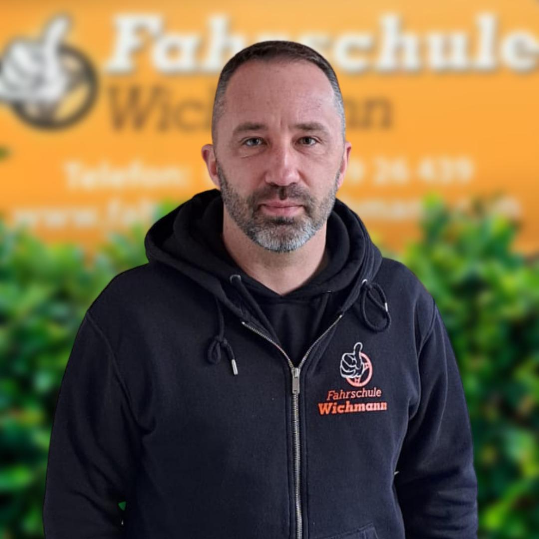 Fahrlehrer im schwarzen Hoodie mit Fahrschule Wichmann Logo in Rastede
