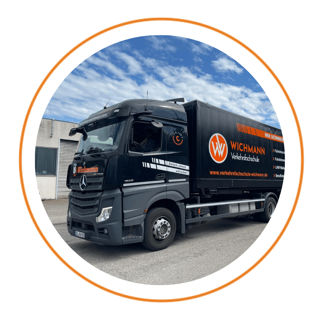 LKW der Fahrschule Wichmann vor dem Standort Rastede bei blauem Himmel