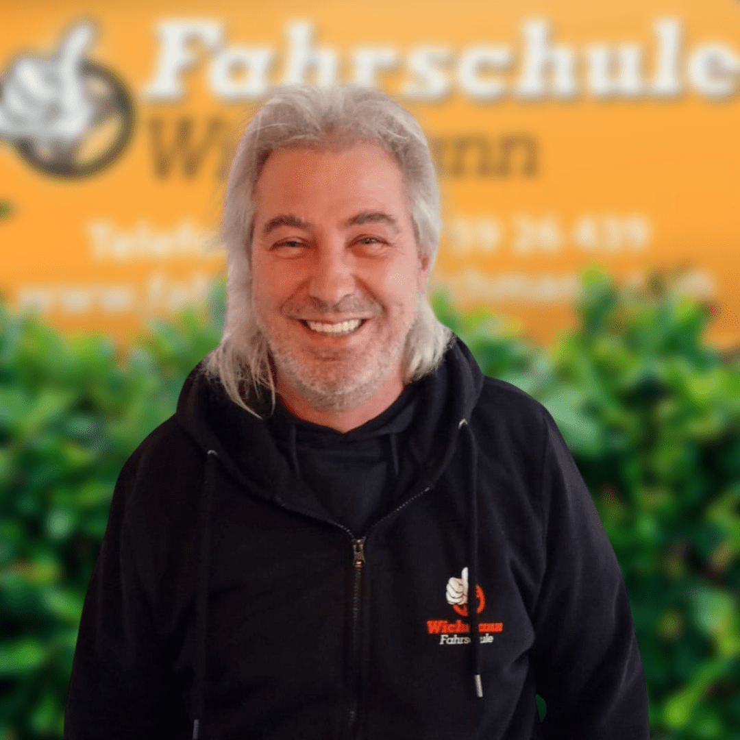 Fahrlehrer mit Wichmann-Logo in Rastede vor grünem Hintergrund